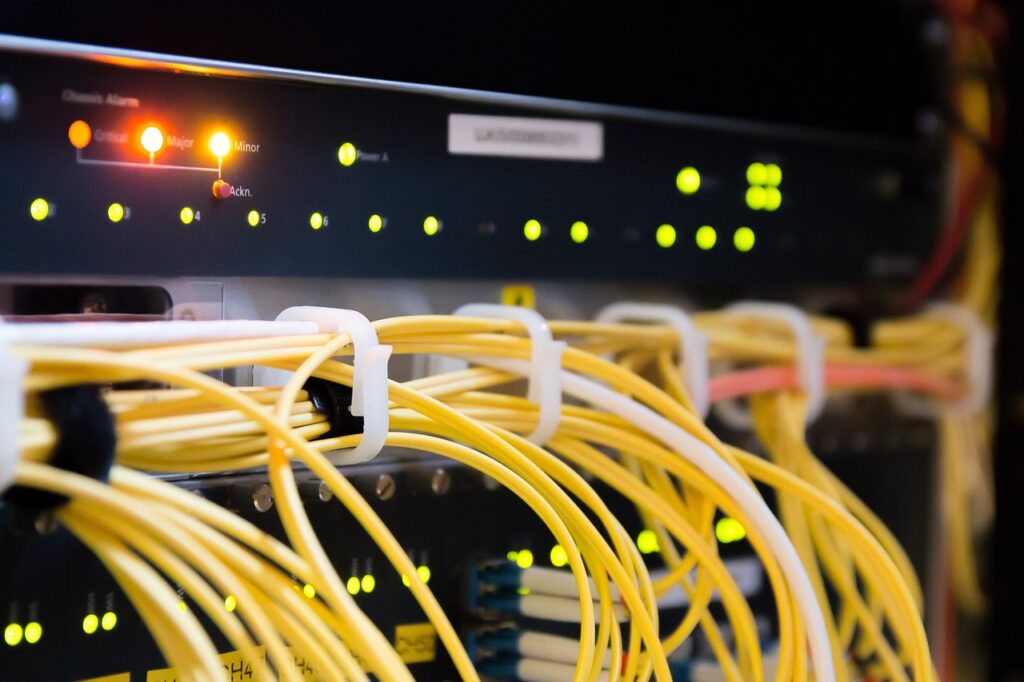 A close-up of a network switch with illuminated indicators and organized yellow cables.